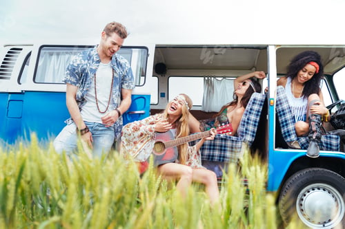 Preview: Happy friends driving a vintage minivan