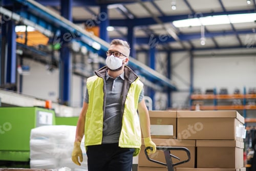 Preview: Man worker with protective mask working in industrial factory or warehouse