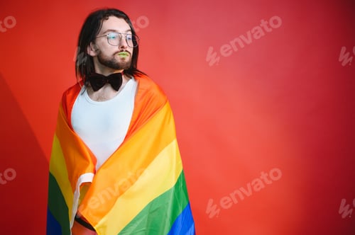 Preview: Gay man hold rainbow striped flag isolated on colored background studio portrait.
