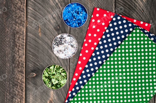 Preview: Cotton polka dots textile for needlework and glitter on old wooden background. Top view