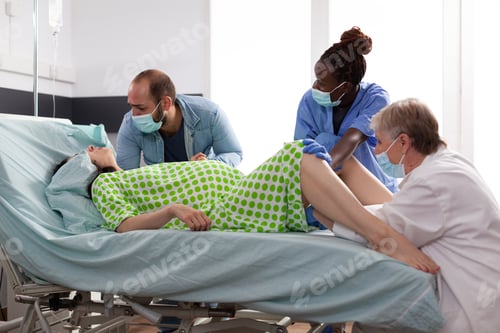 Preview: Multi ethnic medical team assisting childbirth for woman