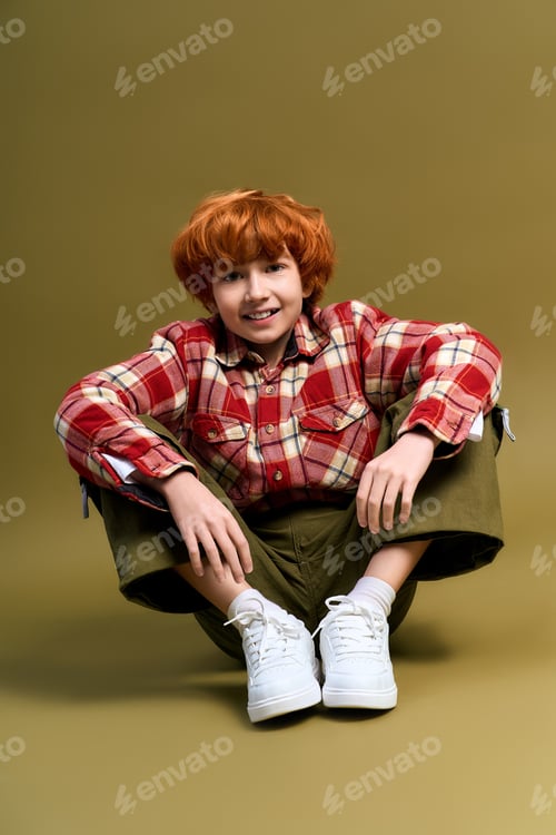 Preview: Little stylish boy showcases his vibrant personality and trendy outfit in a playful pose