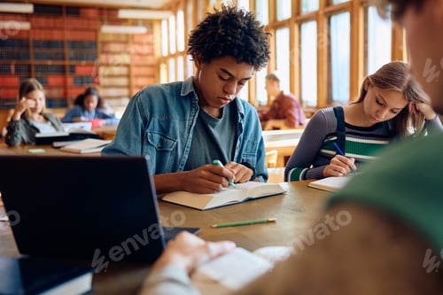 Preview: Black high school student learning with friends in a library,