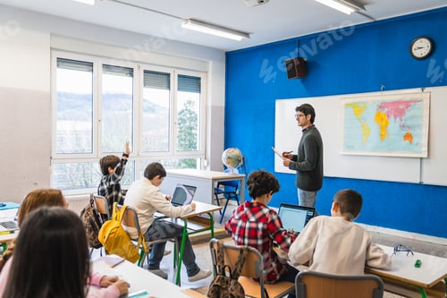 Preview: Elementary school students raising hand and learning geography in classroom