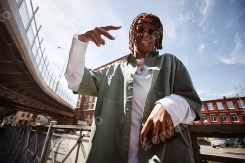 Aperçu: Happy young African American man with dreadlocks performing hip hop dance