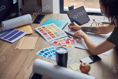 Preview: Close up shot of working process of interior designer making notes in her notebook, selecting