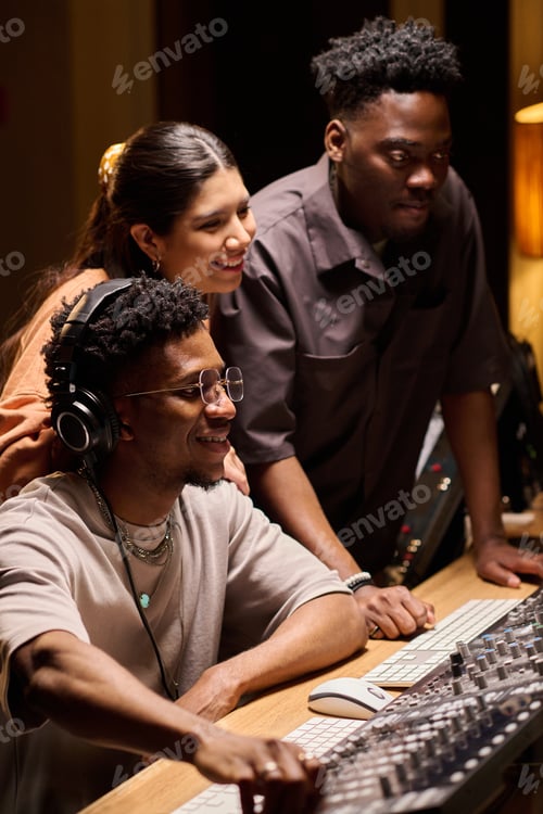Preview: Multiethnic Young Adults Collaborating at Audio Mixing Console in Recording Studio