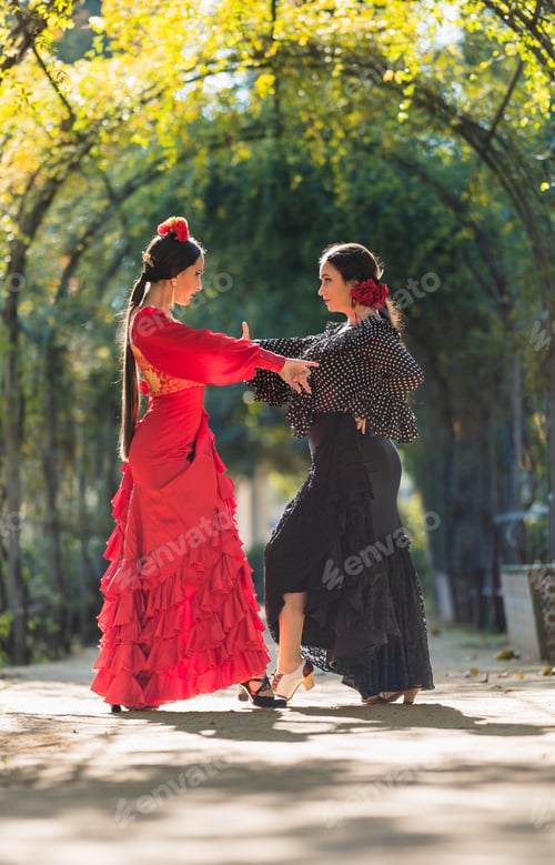 Preview: Two women in flamenco dresses dancing surrounded by an arch of plants