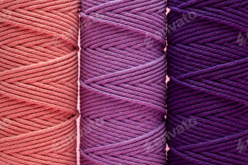 Preview: Three rolls of braided macrame cord in various shades of purple and coral pink.