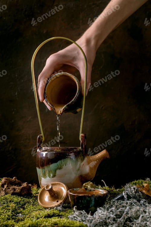 Preview: Craft handmade ceramic teapot on moss as background