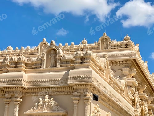 Preview: Detailed view of ornate carvings on the exterior of a Hindu temple under a clear blue sky in Houston