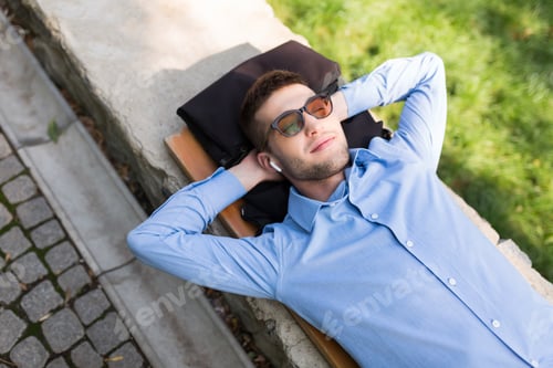 Preview: Young attractive smiling man in shirt and sunglasses with wirele
