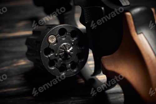 Preview: revolver cylinder with one Flobert ammo 4mm on dark wooden background. Russian roulette concept