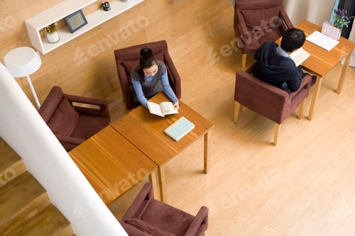 Preview: Two people reading books at a coffee shop