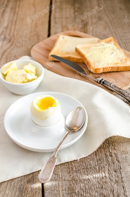 Preview: Boiled egg with crispy toasts on the wooden table