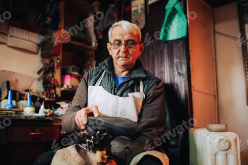 Preview: A senior cobbler is fixing an old boot in his workshop.