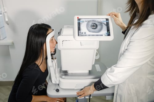 Preview: Woman doing eye test checking examination with optometrist