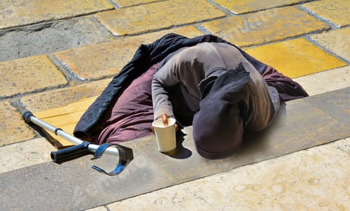 Preview: A woman in black clothes with a crutch begging for alms lying on the stairs