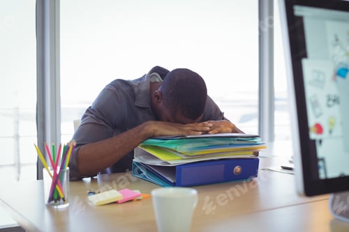 Preview: Businessman sleeping on files at desk