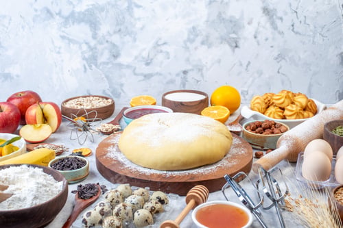 Preview: Top view of raw pastry and set of various foods grater on ice background