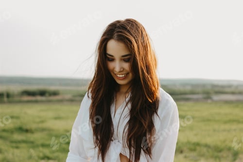 Beautiful carefree long hair asian girl in white clothes and straw hat enjoys life at field