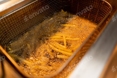 Preview: professional cuisine in the hotel restaurant french fries fried in hot oil in deep fryer close-up