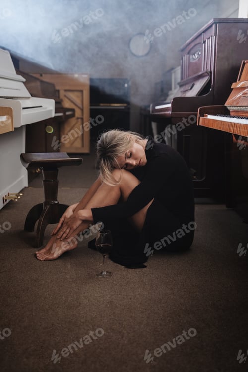 Preview: Portrait of a Young Woman in Black Dress Amidst Pianos in a Warehouse