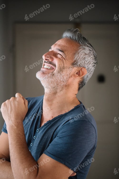 Preview: Portrait of laughing mature man at home