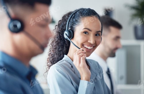 Preview: Portrait of a young call centre agent working in an office alongside her colleagues