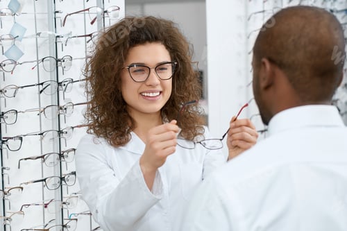 Preview: Backview of man trying on eyeglasses in optical shop