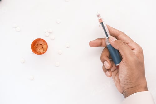 Preview: hand holding Insulin pens on white background, close up