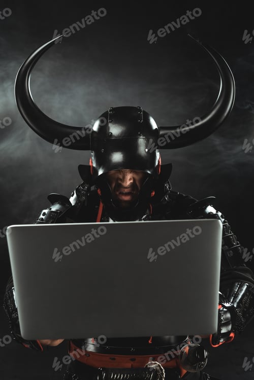 Preview: angry samurai in armor using laptop on dark background with smoke