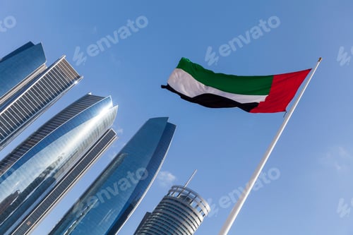 Preview: UAE flag with modern high rise buildings at the background in Abu Dhabi