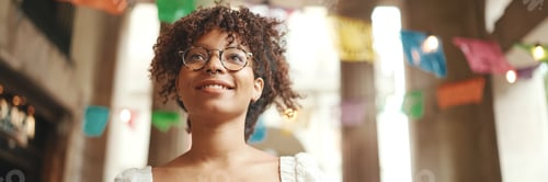 Preview: Positive woman using mobile phone outdoors in urban background.