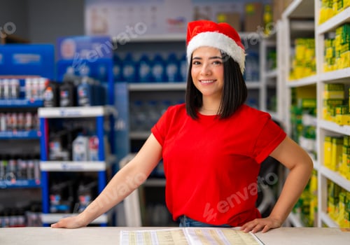 Preview: Young woman wearing a santa hat and red shirt smiling in an auto parts store