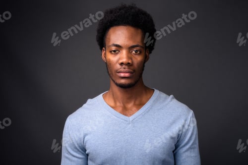 Preview: Young handsome African man against gray background