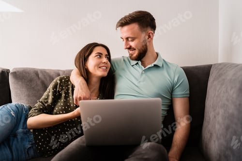 Preview: Affectionate Couple Relaxing on Sofa with Laptop