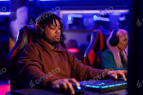 Preview: An interracial gamer with headset in practicing for esport tournament.