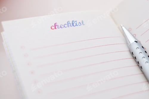 Preview: Close up of a note book with a checklist page open and a silver pen beside it