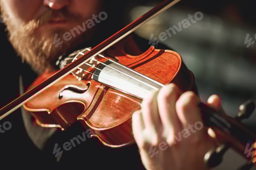 Preview: Playing classical music. Close up view of beard violinist playing classical music on the brown wood