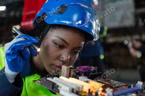 Preview: Female african american professional technician checking computer motherboard.