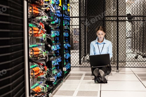 Preview: Caucasian woman technician working on computer servers in a server farm.