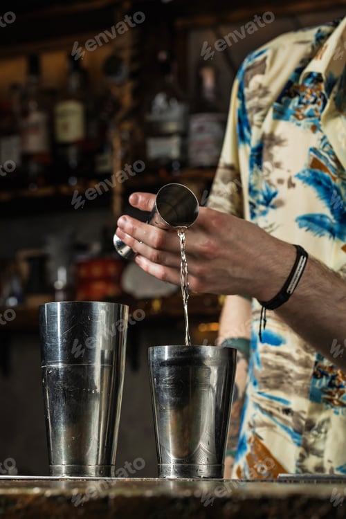 Preview: Bartender pouring liquid from a jigger into a shaker