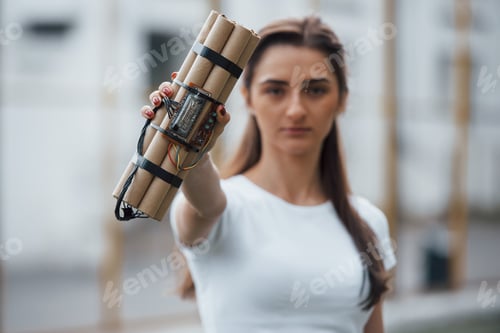 Preview: Digital elements. Showing time bomb. Young woman holding dangerous explosive weapon in hand