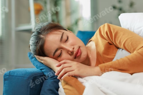 Preview: Young Asian Woman Sleeping Peacefully on Comfortable Sofa at Home
