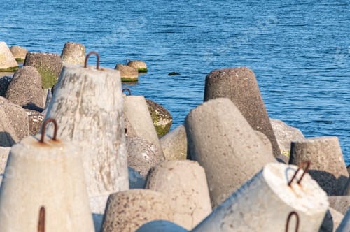 Preview: Breakwaters in sea. Beautiful sunset seascape with concrete tetrapodes