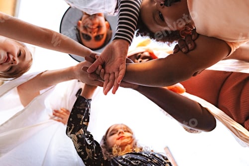 Visualização: Children joining hands during Halloween celebrations, symbolizing unity and friendship