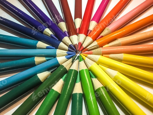 Preview: Many different color artist colored pencils in a circle forming a bull’s-eye in center pencil point