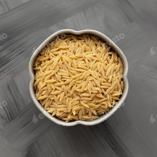 Preview: Raw Organic Orzo Pasta in a Bowl, top view. From above, overhead, flat lay.