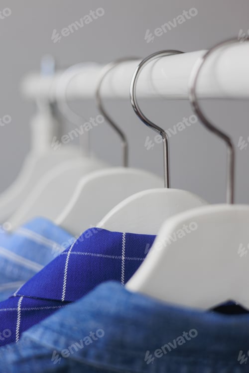 Preview: Blue Shirts Hanging on Rack in Clothing Store